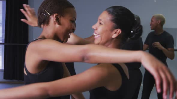 Multi-ethnic group of fit male and female modern dancers embracing each other