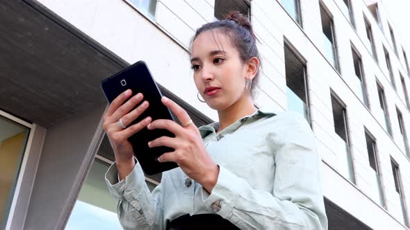 Young Entrepreneur checking his tablet while looking confident, young women in business