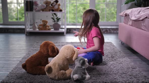 Cute Child Playing with Teddy Puppies in Nursery