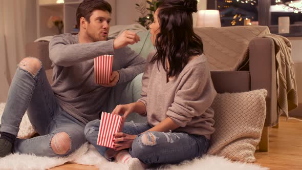 Happy Couple Eating Pop Corn at Home