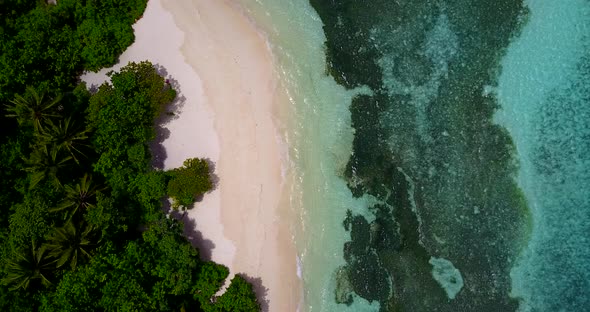 Beautiful above travel shot of a sandy white paradise beach and blue sea background in hi res 4K