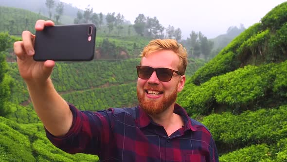 Redhaired Ginger Bearded Man in Sunglasses Talking By Smartphone Video Chat and Say Hello From India