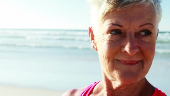 Smiling senior woman standing on beach