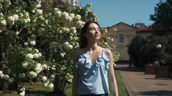 Graceful Freedom Loving Brunette Is Walking in Summer Garden in Daytime