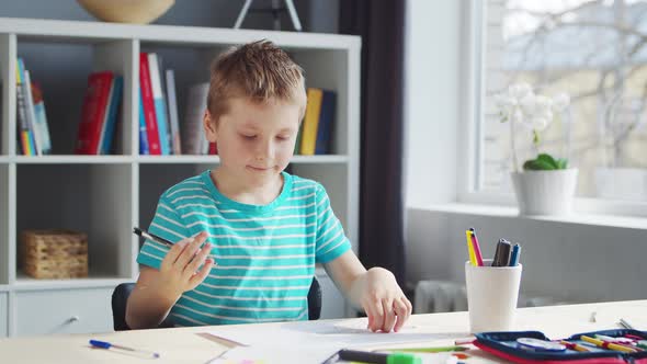 Boy is Doing  Homework at the Table. Cute Child is Learning at Home.