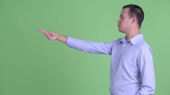 Profile View of Happy Asian Businessman Pointing Finger