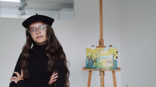 Portrait of Happy Artist Female Posing Near Easel with Completed Drawing After Working Looking to