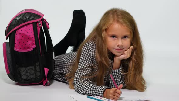Schoolgirl at Home Drawing While Lying on the Floor