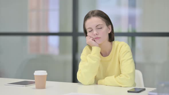 Tired Young Woman Sleeping While Sitting in Office