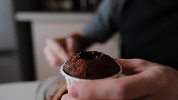 Pastry Chef in the Kitchen Puts Chocolate in a Chocolate Muffin Closeup