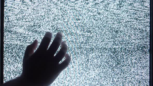 Human Hand Touching Old Retro Television Screen with Ripples Wavy Flowing Damaged Signal