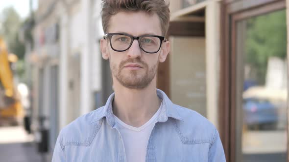 Serious Young Man Standing Outdoor along Road