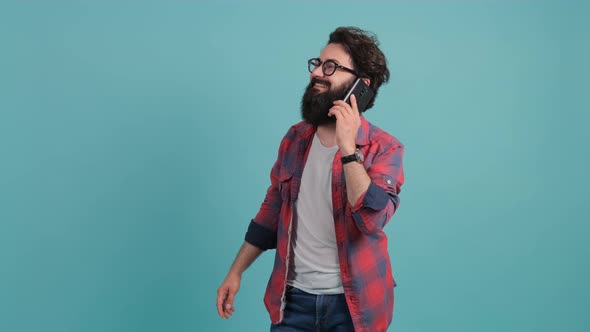 Portrait of Happy Brunette Bearded Man Having a Pleasant Mobile Conversation