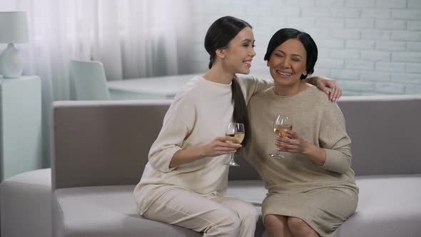 Two happy asian women drinking white wine, celebration of victory, partnership