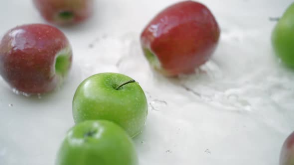 SLOMO of Apples in Water on White Backdrop