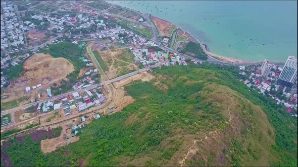 Aerial View Over Large Mountain Peak and Modern City