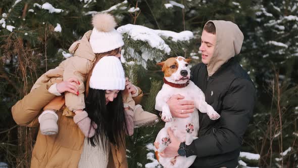 Parents with Daughter Walking in Forest in Winter