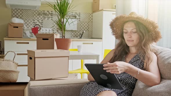 Woman Using Tablet with Boxes at the Back. Portrait of Young Beautiful Woman with Mobile Phone