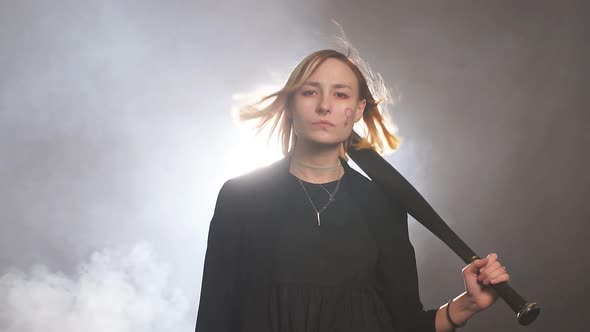 Portrait of Young Caucasian Girl Feminist Isolated in Smoky Space, Wearing Black Blouse, Look at