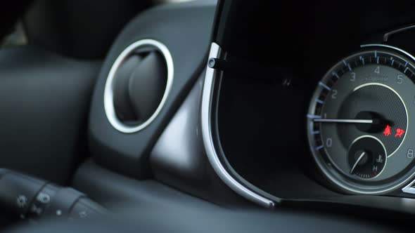 Close Up of Car Dashboard with an Engine Speed Dial and Tachometer