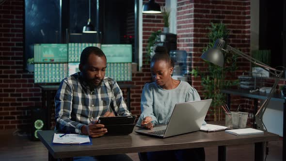 Man and Woman Monitoring Real Time Stock Market Graphs