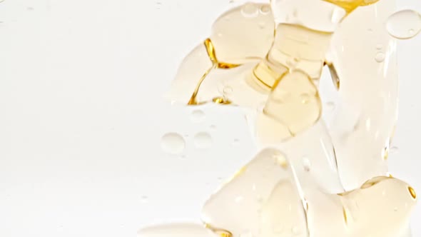 Slow Motion of Moving Yellow Golden Oil Air Bubbles in Water Rising Up on Light White Background