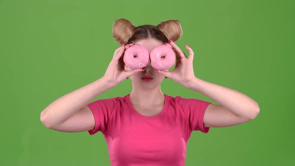 Girl Holds Donuts in Her Hands and Closes Her Eyes. Green Screen. Slow Motion