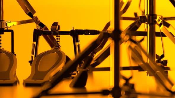 Details of drum kit on a bright yellow background. Double pedals, hi-hat stand.