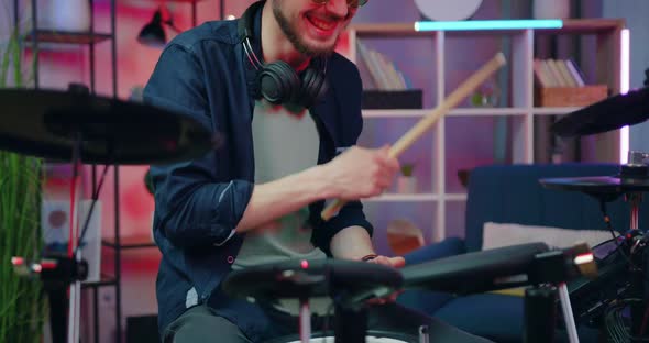 Male Drummer Enjoying His Play on Drums in Home Studio