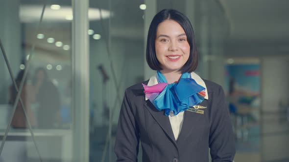 Beautiful Caucasian flight attendant staff smiling and stand with confidence in airport terminal.