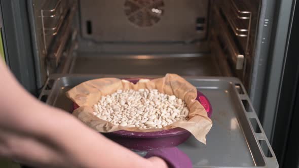 Woman Puts a Baking Tray with Raw Quiche Pie in the Oven