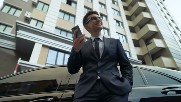 Young Male in Suit Reading Good News on Phone