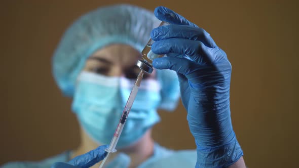 Doctor in Latex Gloves Fill in Syringe with Medicine From Glass Vial Close Up