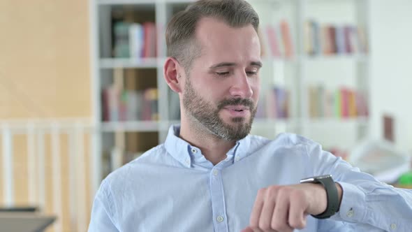 Portrait of Young Man Talking on Smart Watch 