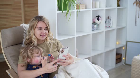 Mom and her little son use the phone, communicate video chat, take photos