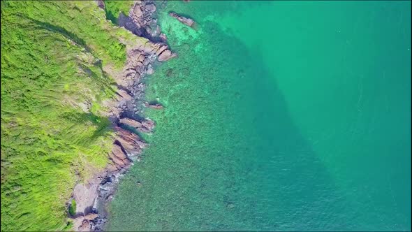 Aerial View Motion Over Steep Cliff Coast with Green Slopes