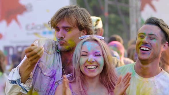 Drunk Young Friends Covered in Colorful Paint Performing Crazy Dance at Festival