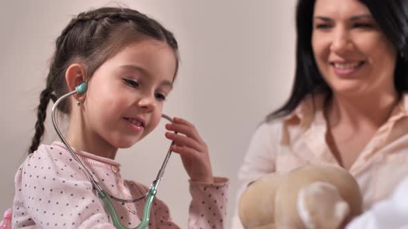 Cute Girl Using Stethoscope in Doctor's Office