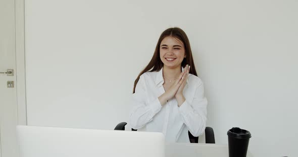 Happy Young Girl Rejoices When Video Chatting at Laptop at Workplace in Office