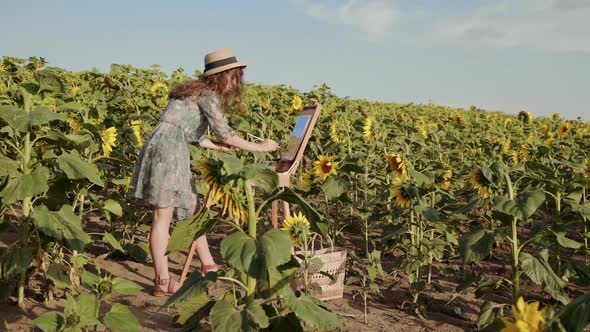 Pretty Curlyhaired Lady Painting in the Bright Spacious Sunflower Field