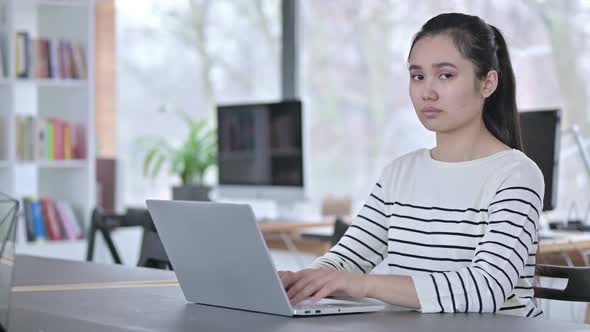No Finger Gesture By Young Asian Woman with Laptop in Office