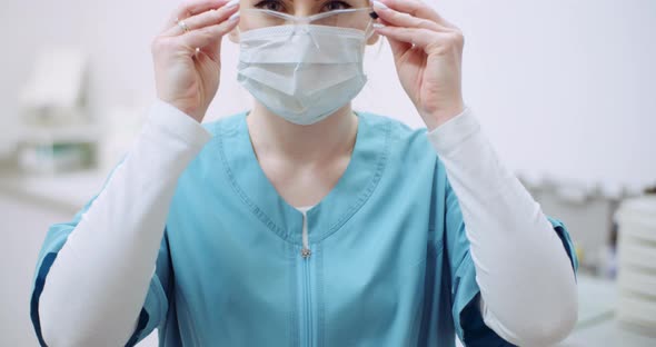 Female Doctor Wearing Protective Mask on Face and Put Glasses. Doctor at Healtcare Clinic