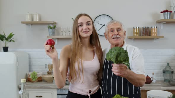 Senior Grandfather with Granddaughter Recommending Eating Raw Vegetable Food. Vegetable Diet