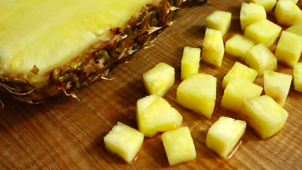 Pieces of pineapple on a cutting wooden board.