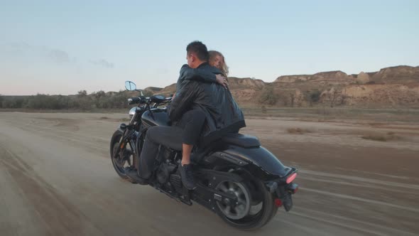 Guy with a Girl on a Motorcycle in the Desert