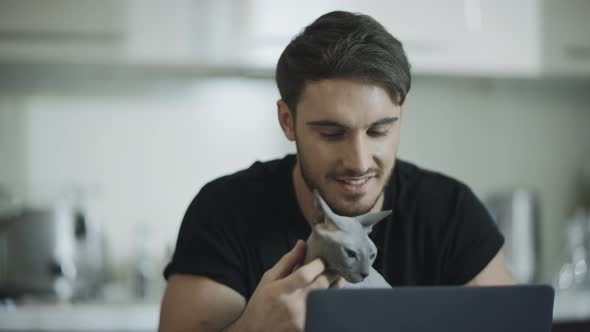 Hipster Man Touching Cat at Home Workplace