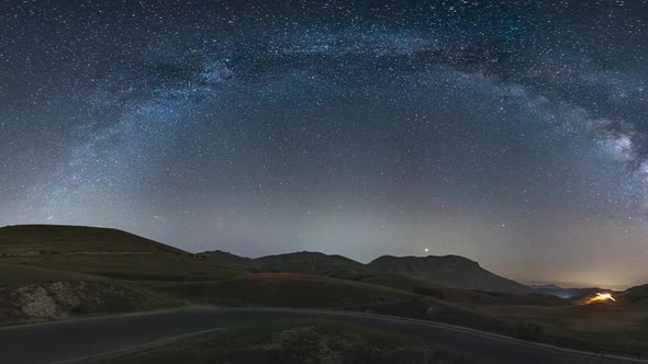 PAN: night sky over Castelluccio di Norcia highlands, Italy. The Milky Way galaxy arc and stars over