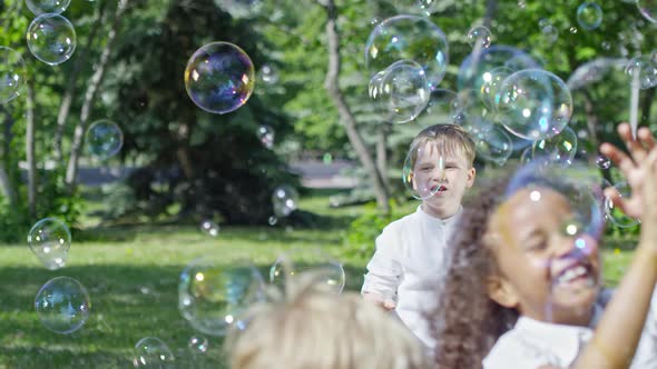 Happy Kids Playing in Park at Bubble Show alt