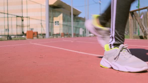 A woman runs on a outdoor treadmill.