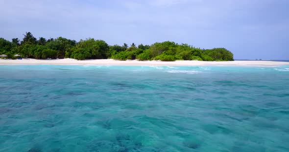 Wide drone travel shot of a summer white paradise sand beach and blue water background in 4K